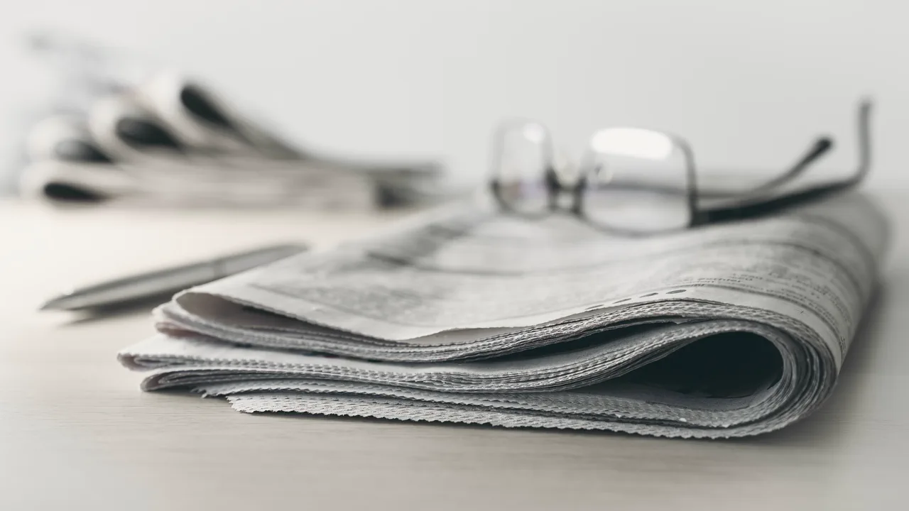 Gefaltete Zeitung mit Brille – AIZ-Beitrag über Flex-Office-Anbieter